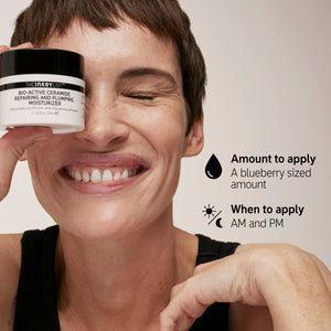 Model smiling with pot of Bio-Active Ceramide Moisturiser